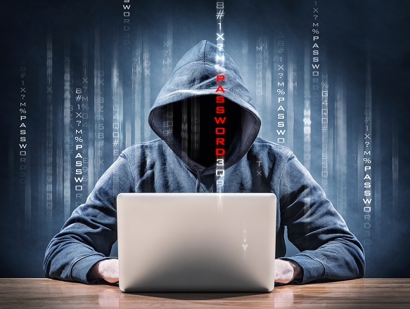 Photo of a computer hacker sitting at a laptop